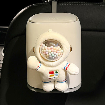 Car air freshener shaped like an astronaut with a gumball machine design, mounted on a car's headrest.